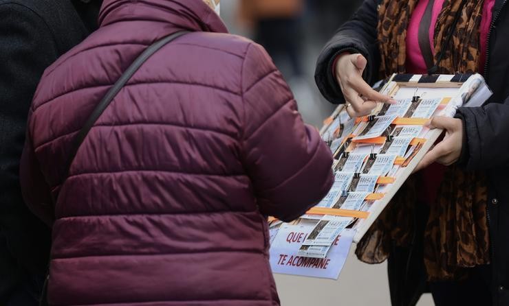 Unha muller compra un décimo de lotaría a unha vendedora ambulante. Eduardo Parra - Europa Press
