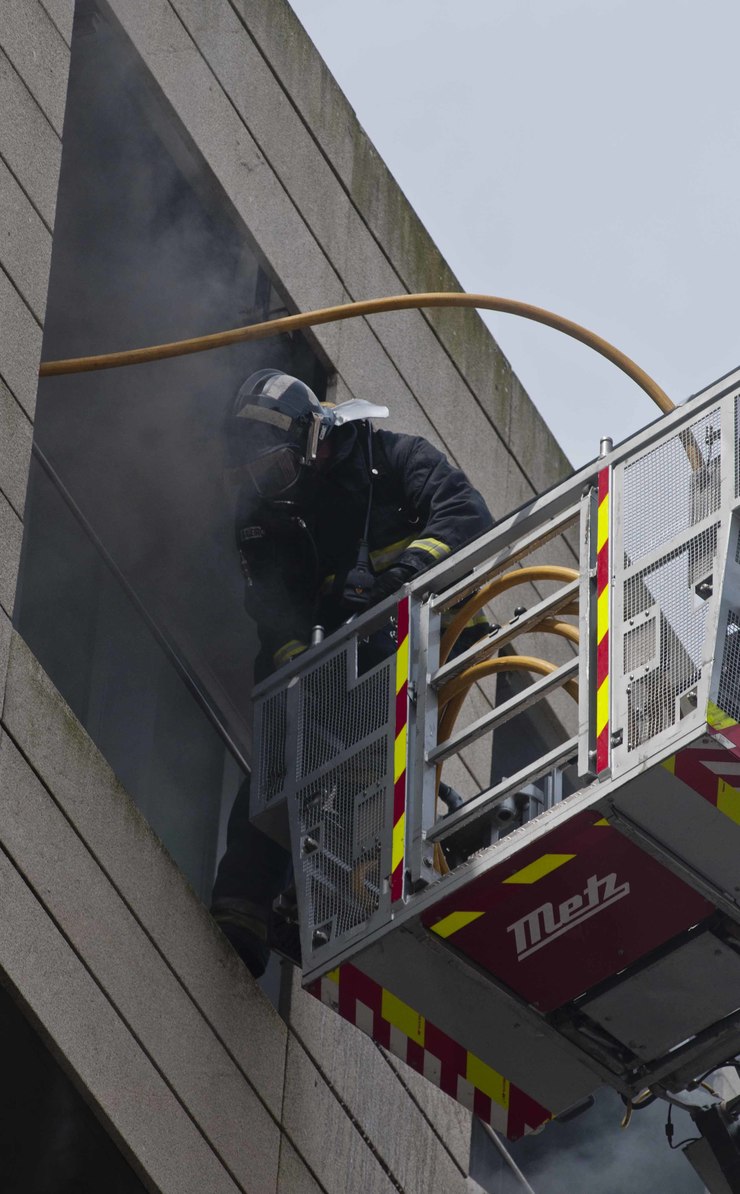 Un bombeiro tenta sofocar o incendio a través dunha  ventá / Miguel Núñez