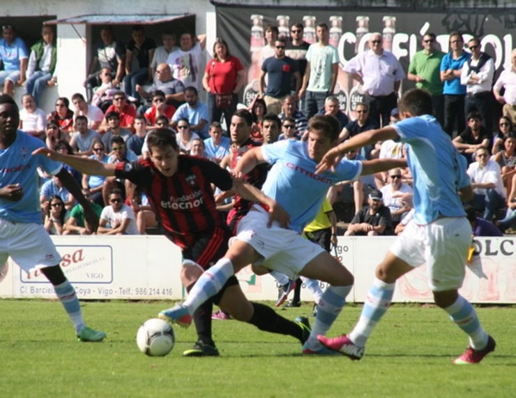 Celta B e Arenas loitan por un balón dividido. 