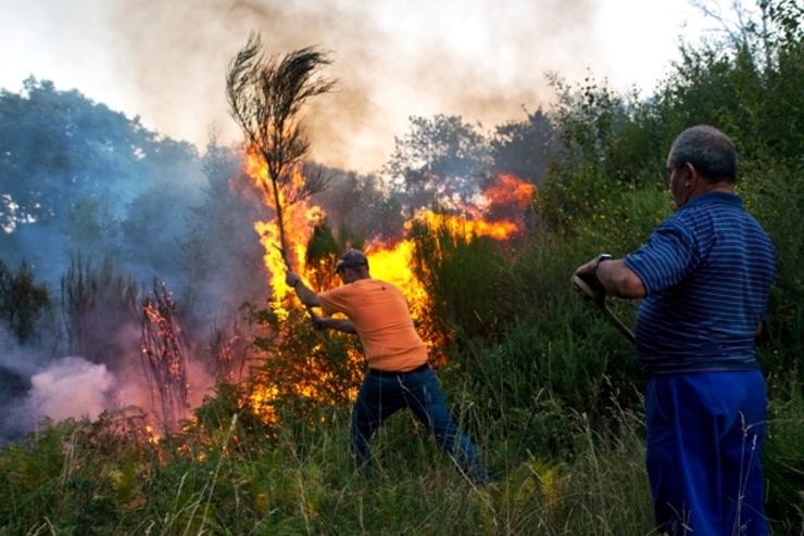 Veciños participando nas labores de extinción dun incendio en Cualedro