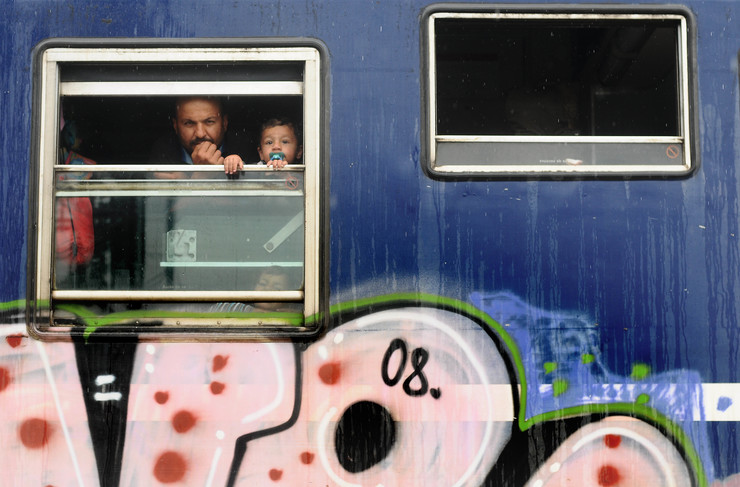 Un pai refuxiado cos seus fillos, nun dos vagóns abandonados na estación de Idomeni 