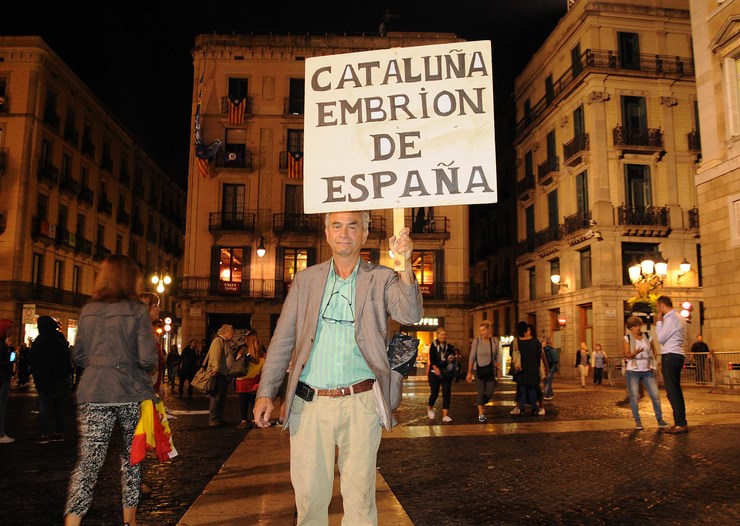 Un home mostra un cartel no centro de Barcelona a prol da permanencia de Cataluña en España 