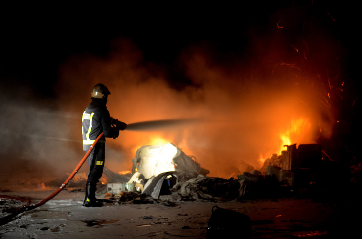 Un bombeiro durante os labores de extinción dun incendio 