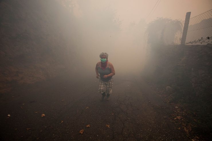 Unha muller en Vincios (Gondomar), no medio do fume causado pola vaga de incendios que asolou Galicia en pleno mes de outubro de 2017 