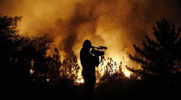 Reporteiro gravando imaxes dun lume 