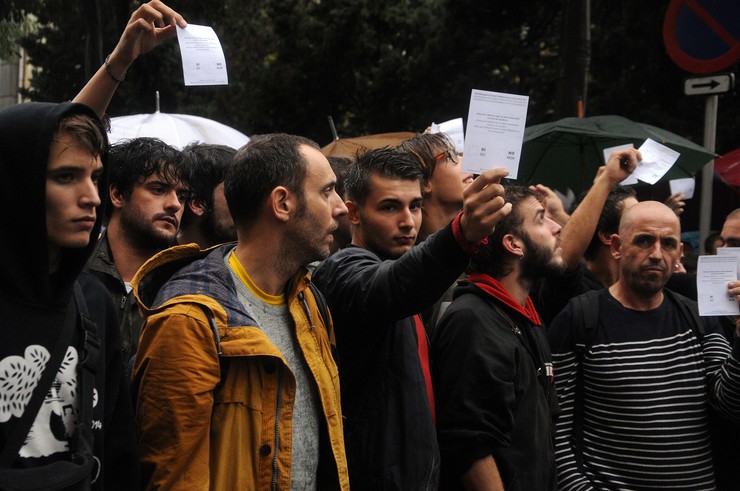 Un gupo de mozos ensina a papeleta ante a presencia da Policía/ Miguel Núñez