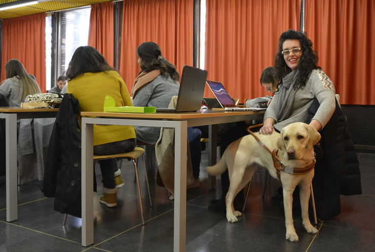Lucía González, coa súa cadela guía Lucy na Universidade de Vigo 