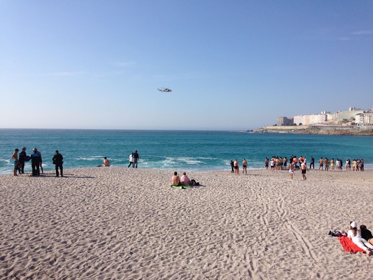 Un helicóptero participa na busca dun mozo desaparecido na praia do Orzán 