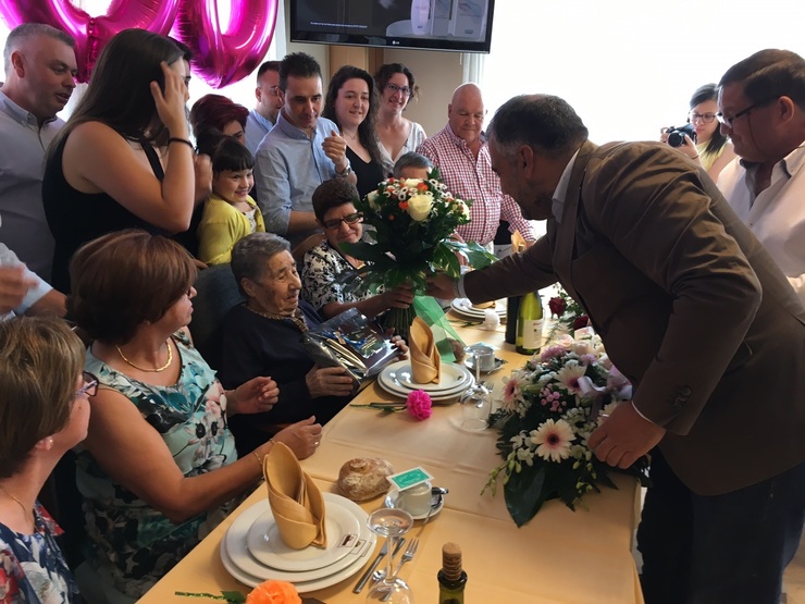 O alcalde fai entrega do ramo de flores á centenaria. 