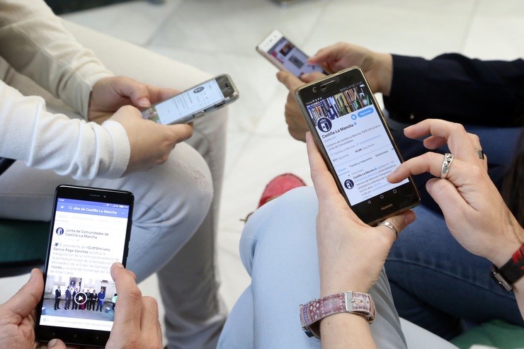 Mozos con teléfonos móbiles accedendo as súas redes sociais en Interne / Arquivo