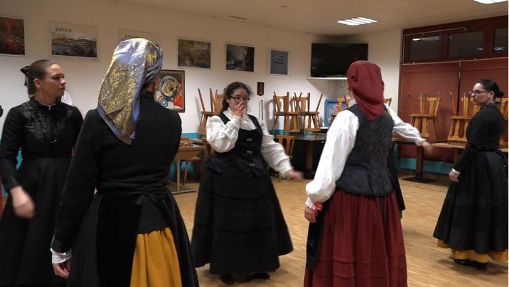 Un grupo de mozos, fillos de emigrantes galegos na Suiza, prepáranse para un baile galego, a muñeira de Cabaleiros