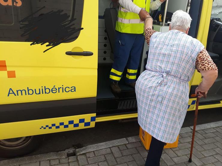 Muller subindo a unha ambulancia usando unha caixa de plástico 