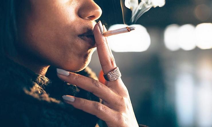 Unha moza fumando un porro ou canuto de marihuana / Revista Cáñamo
