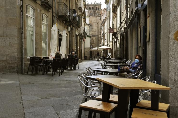 Unha muller permanece sentada nunha terraza do barrio do Couto o mesmo día no que prohibiron as reunións entre non convivientes ante o aumento de contagios de Covid-19. En Ourense, Galicia, (España), a 3 de outubro. Esta medida, imposta por Sa. Rosa Veiga - Europa Press 