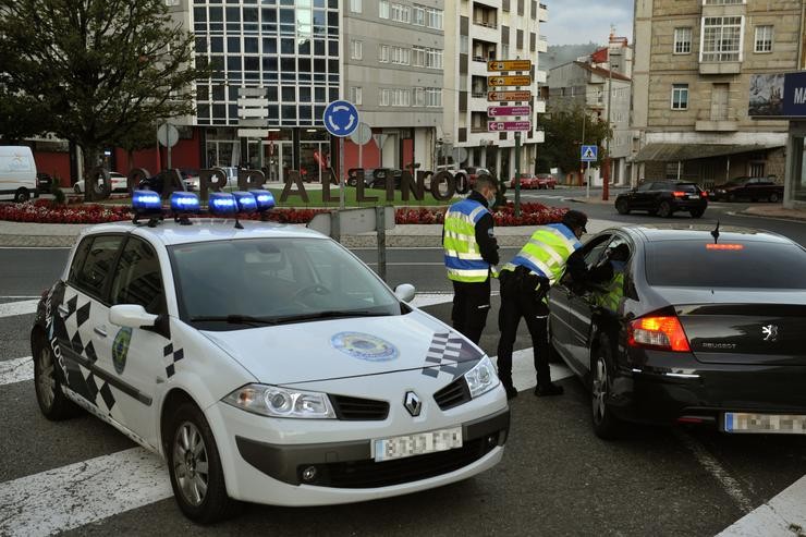 Dous axentes pairan a un vehículo nun control realizado no Carballiño, Ourense, Galicia (España), a 15 de outubro de 2020. Desde hoxe, a Xunta limita as entradas e saídas das localidades ourensás de Carballiño, O Irixo e Boborás, que quedan delimi. Rosa Veiga - Europa Press / Europa Press