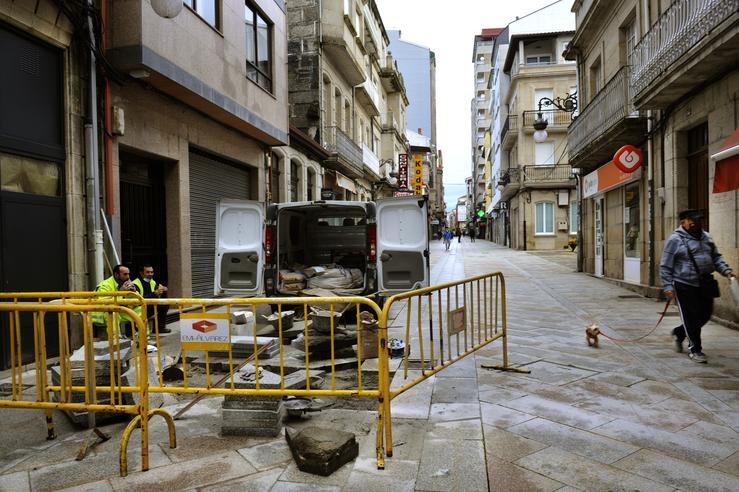 Traballadores municipais xantan durante un descanso do seu traballo arranxando a rúa principal do pobo do Carballiño, a Rúa Tomás María Mosquera, no Carballiño, Ourense, Galicia (España), a 22 de outubro de 2020. O comité clínico da Cons. Rosa Veiga - Europa Press 