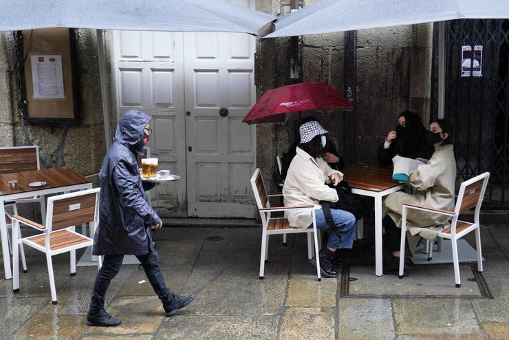 Unha camareira leva varias cervexas a unha das mesas da terraza do seu establecemento, en Santiago de Compostela, A Coruña (Galicia),. Álvaro Ballesteros - Europa Press