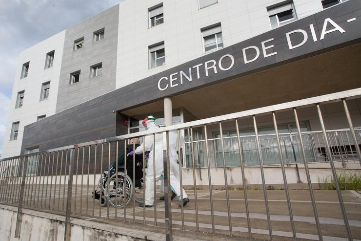 Un traballador sanitario totalmente protexido acode a buscar a un ancián da residencia de San Cibrao onde se orixinou un gromo de Covid-19 