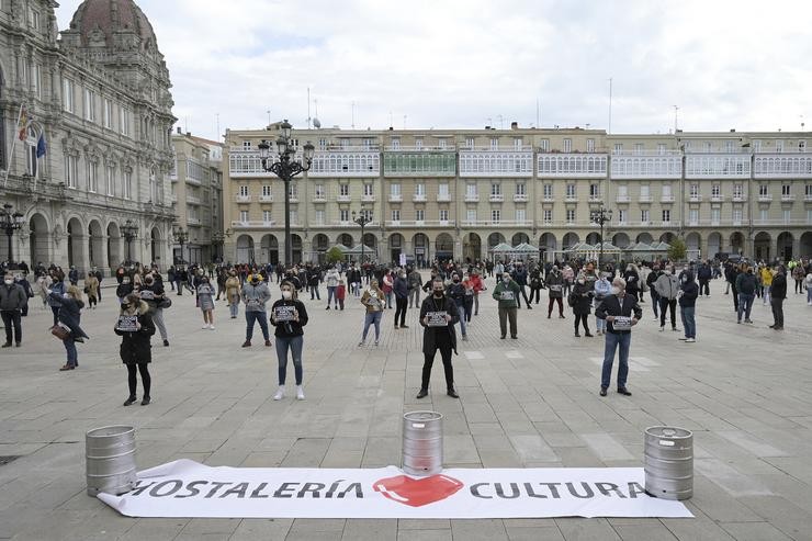 Grupos de persoas concéntranse en fila da catro na praza de María Pita contra as restricións impostas ao sector hostaleiro, na Coruña 