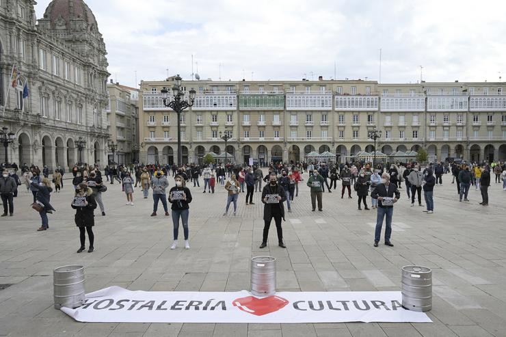 Grupos de persoas concéntranse en fila da catro na praza de María Pita contra as restricións impostas ao sector hostaleiro 