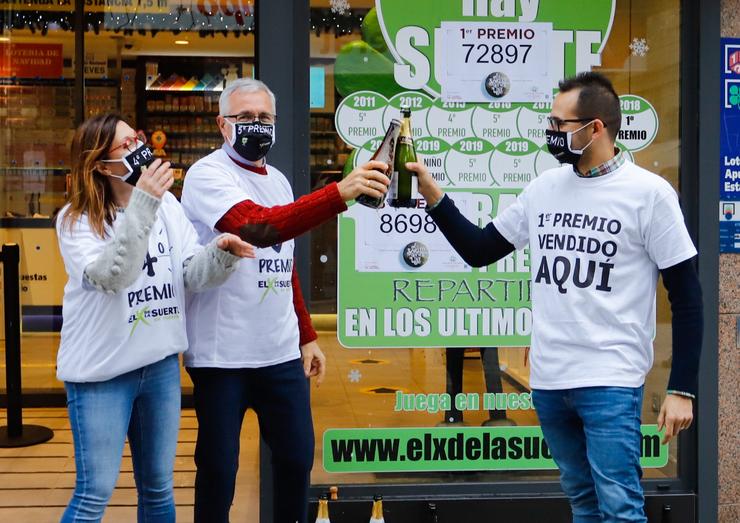 Tres loteiros brindan con champaña na administración de lotaría situada na rúa Ramón González, 7 na que se repartiu parte do número `72.897´ correspondente a 