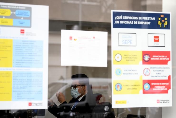 Un home con máscara tras o cristal da porta dunha oficina de emprego, SEPE. Óscar Canas - Europa Press