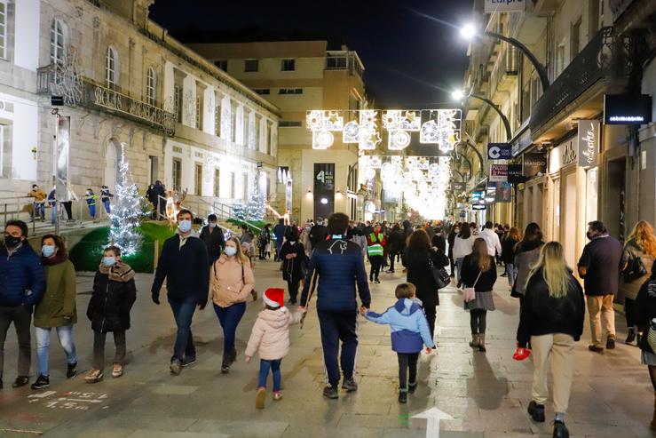 Transeúntes pasean baixo as luces do Nadal, levando máscara, algún con gorro do Nadal, en Vigo, Galicia (España), a 25 de decembro de 2020. Marta Vázquez Rodríguez - Europa Press 