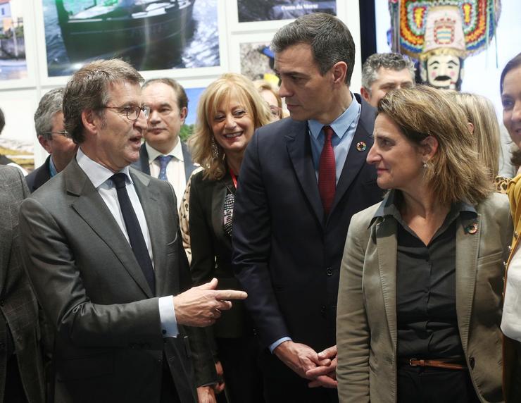 O presidente da Xunta de Galicia, Alberto Nuñez Feijóo (esq), o presidente do Goberno, Pedro Sánchez (centro) e a vicepresidenta de Transición Ecolóxica, Teresa Ribera (der), falan durante a súa visita pola Feira Internacional de Turismo, Fitur 