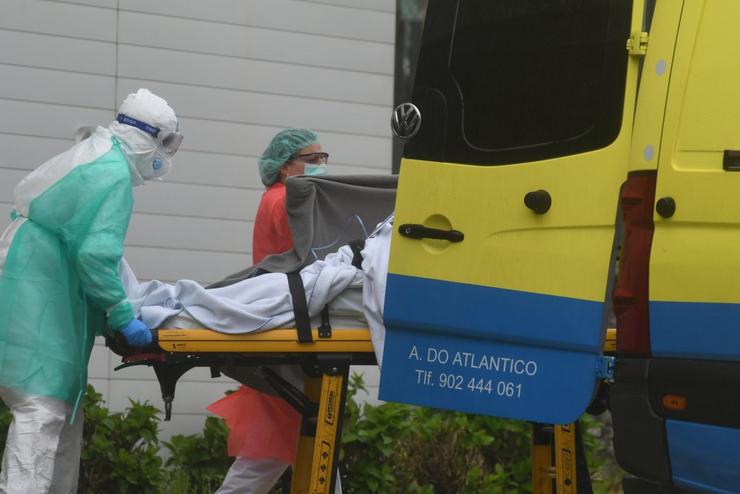 Un infectado de coronavirus sendo trasladado en ambulancia ao hospital por persoal sanitario 