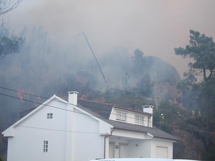 Brigadistas apagan lume nas inmediacións das casas en Ou Ézaro. EUROPA PRESS - Arquivo / Europa Press