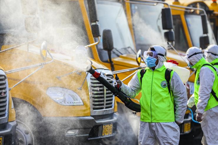 Voluntarios esparexendo desinfectante en China.