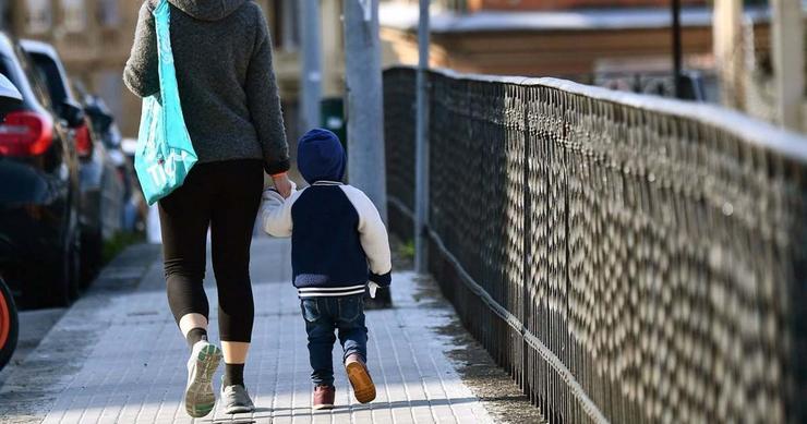 Un cativo dá un paseo acompañado dunha persoa adulta