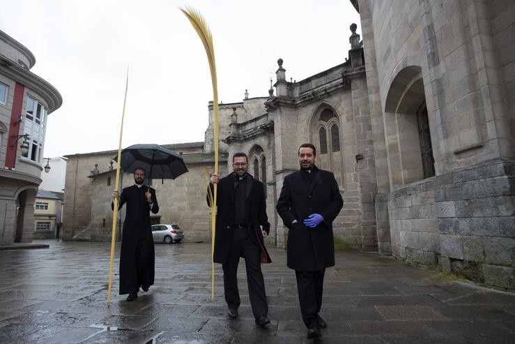 Tres curas camiñan con palmas bendicidas durante o Domingo de Ramos en Lugo tras a suspensión da Semana Santa polo estado de alarma do coronavirus, en Lugo