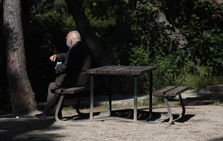 Un ancián con máscara descansa nun parque. Eduardo Parra - Europa Press