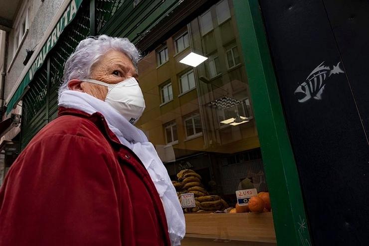 Unha muller espera na entrada dun local comercial durante o estado de alarma provocado pola crise do coronavirus. CARLOS CASTRO - EUROPA PRESS - Arquivo