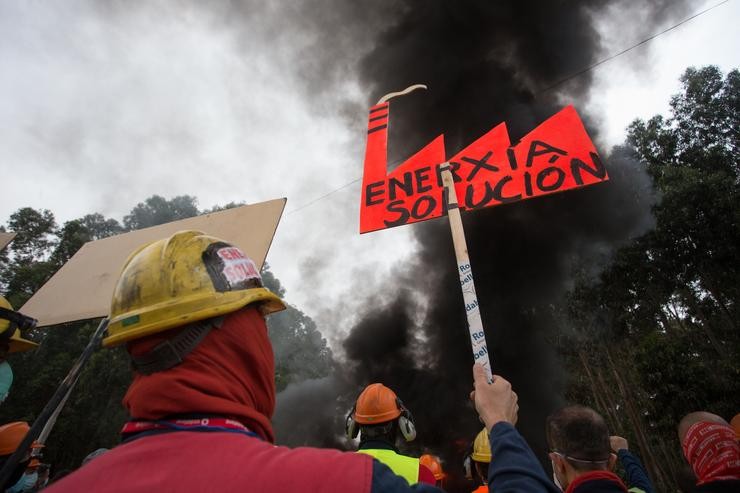 Participantes protexidos con máscara suxeitan unha pancarta durante a manifestación do comité de empresa de Alcoa. Carlos Castro - Europa Press 