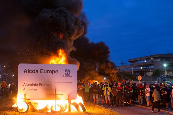 Manifestantes durante unha concentración nocturna convocada polo comité de Alcoa San Cibrao, na contorna da fábrica de San Cibrao, queiman o cartel da multinacional en Lugo, Galicia (España), a 30 de xuño. Carlos Castro - Europa Press