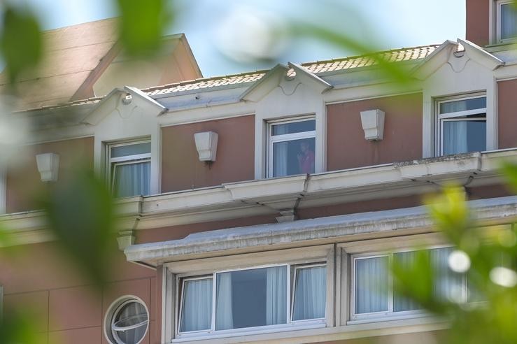 Unha persoa mira por unha xanela do hotel NH Finisterre da Coruña onde os xogadores do CF Fuenlabrada permanecen confinados nel tras dar positivo en coronavirus varios dos seus membros 