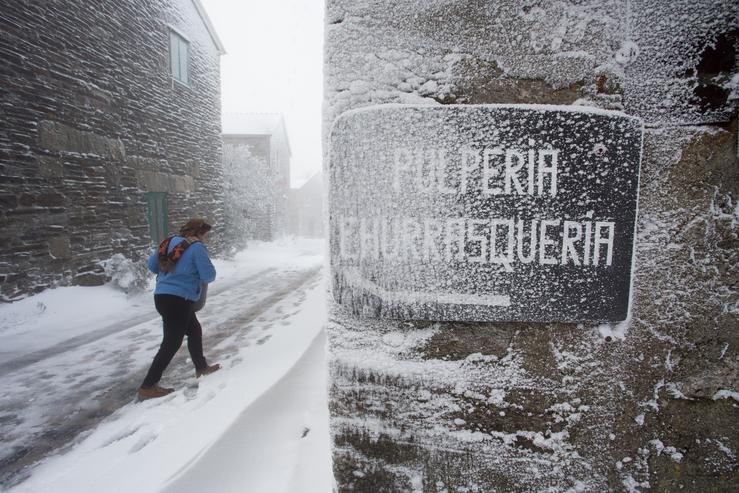 Unha veciña camiña entre a neve en Pedrafita do Cebreiro, en Lugo / Europa Press - Arquivo.