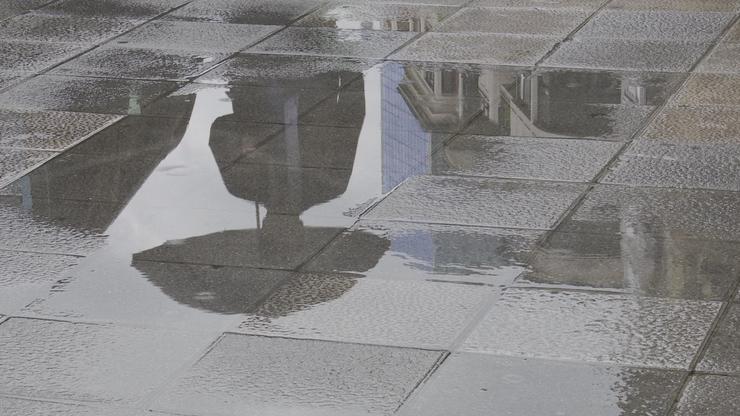 Unha persoa con paraugas reflíctese nun charco provocado pola choiva esta mañá en Bilbao.. EUROPA PRESS - Arquivo 