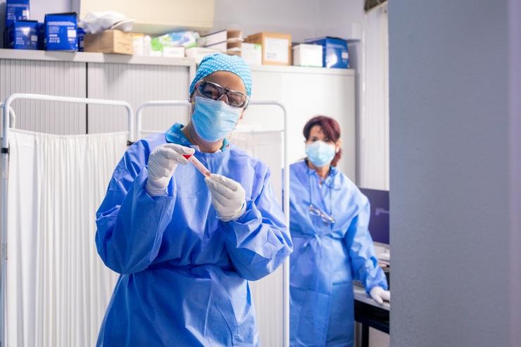 Un traballador sanitario protexido sostén unha das probetas utilizadas para a realización de tests PCR .. Ricardo Rubio - Europa Press