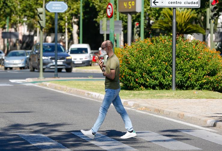 Un peón paseando con máscaras cando o  termómetro marca 44º na Avenida da Palmeira de Sevilla nun día no que a cidade está  en alerta amarela por altas temperaturas. Sevilla a 22 de xuño do 2020. EDUARDO BRIONES - EUROPA PRESS - Arquivo 