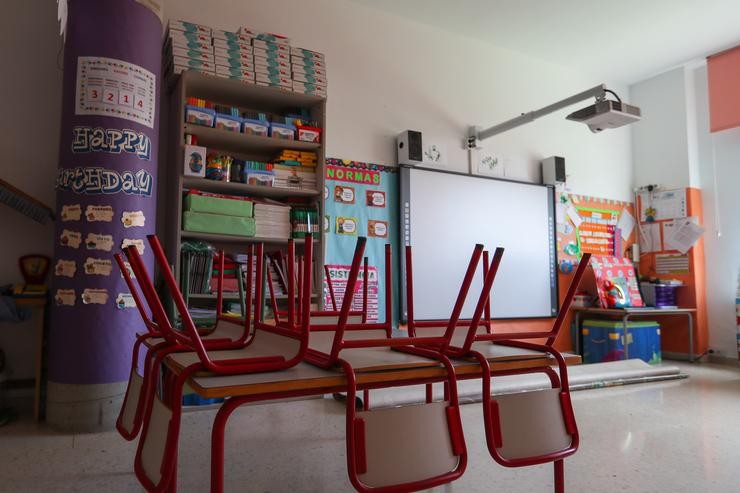 Mesas e cadeiras recollidas nunha aula  