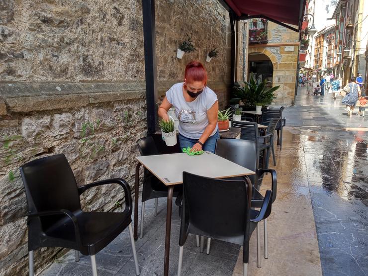 Unha traballadora desinfecta a terraza dun bar en Ermua (Bizkaia) 