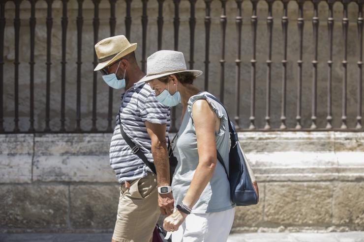 Dúas persoas camiñan con máscara 