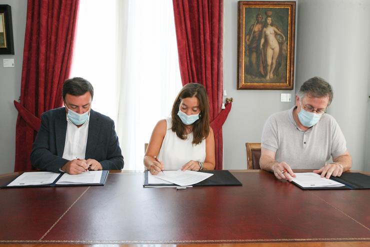 O presidente da Deputación da Coruña, Valentín González Formoso, e a alcaldesa, Inés Rey, asinan un convenio de colaboración  sobre a OSG, xunto ao deputado de Cultura, Xurxo Souto 