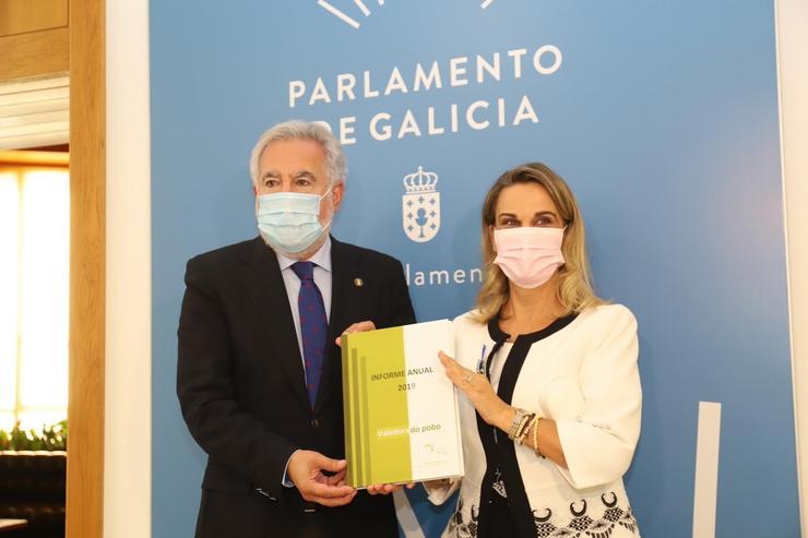 A valedora do Pobo, María Fernández Galiño, entrega a memoria de 2019 ao presidente da Cámara galega, Miguel Anxo Santalices. VALEDOR DO POBO