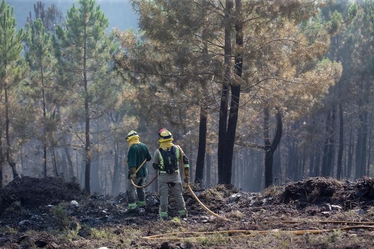Dous bombeiros das brigadas antiincendios da Xunta de Galicia traballan nos labores de extinción dun incendio / Carlos Castro - Europa Press.