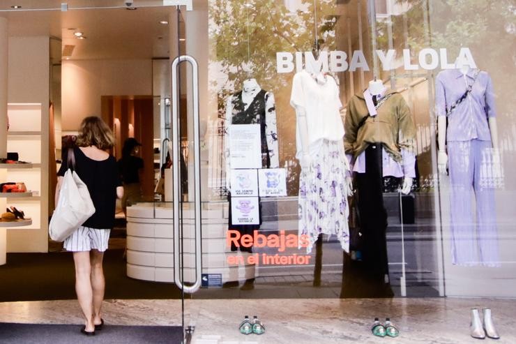 Unha muller entra pola porta dunha das tendas físicas da marca Bimba y Lola 