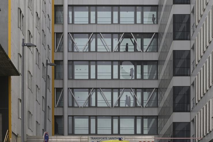 Varios pacientes pasean por un corredor acristalado do Complexo Hospitalario Universitario A Coruña, onde un paciente procedente de Madrid está illado por coronavirus, na Coruña